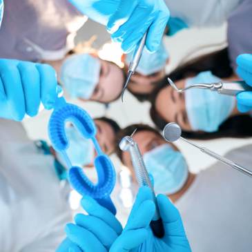 Photo of a team of dental professionals holding instruments.