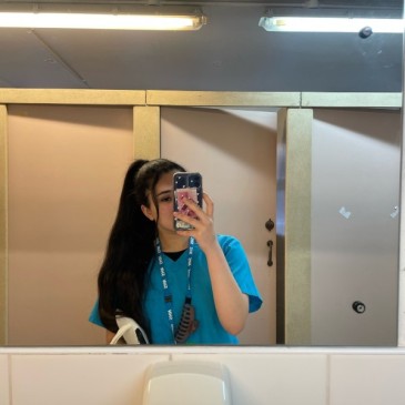 Anna-Maria taking photo in mirror wearing dental uniform