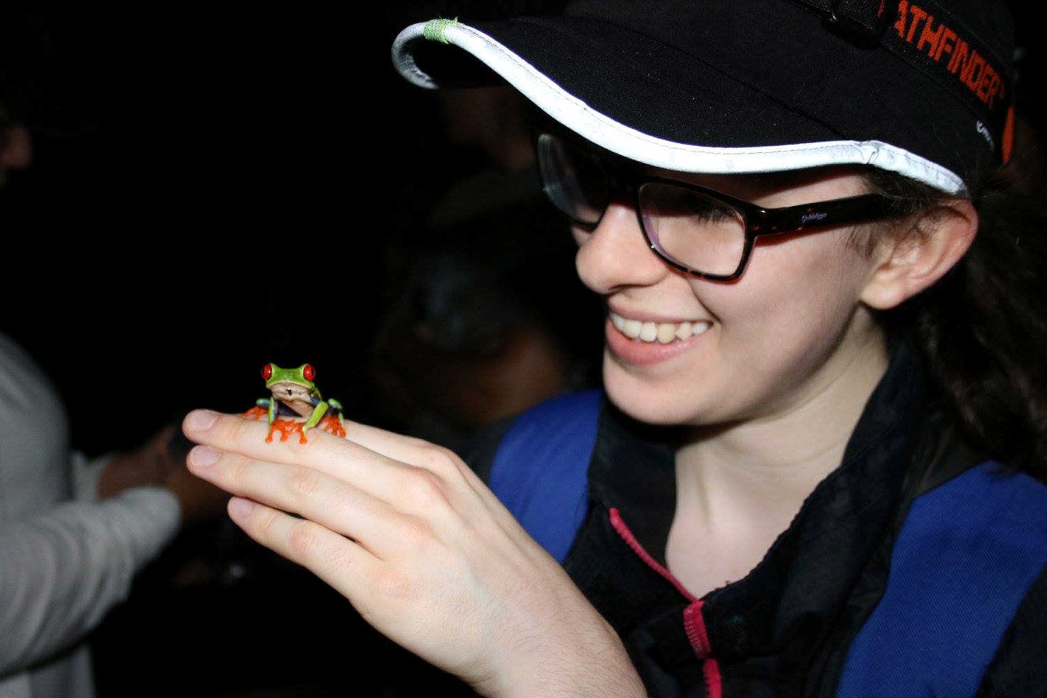 Jenn looking at a tree frog on her Zoology year abroad.